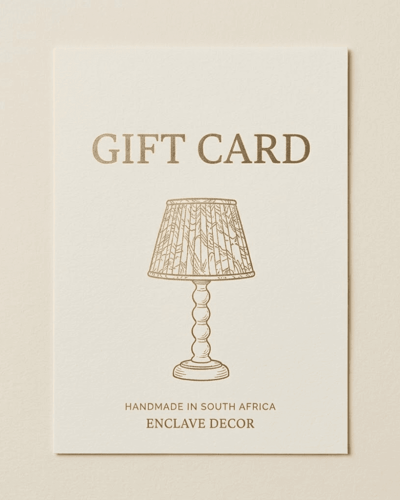 Cream and gold Enclave Decor gift card featuring a bobbin lamp base and pleated lampshade illustration